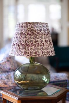 a lamp that is sitting on top of a table in front of a couch and chair