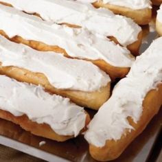 there are many doughnuts with white frosting on them in the tray together