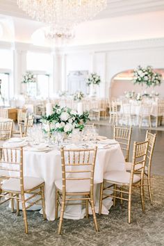 an elegant wedding reception with white flowers and greenery