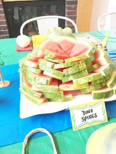 watermelon slices stacked on top of each other at a table with blue cloths