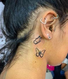 a woman's ear with butterfly tattoos on her left side and behind the ear