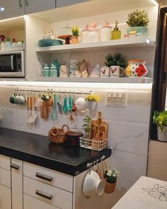 a kitchen counter with pots and pans on the shelf above it, next to a microwave