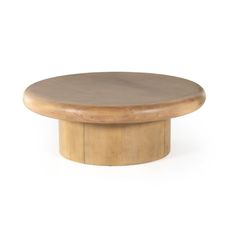 a round wooden table sitting on top of a white floor