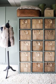 a coat rack with clothes hanging on it next to a fur vest and other items