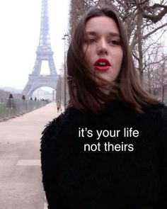 a woman standing in front of the eiffel tower