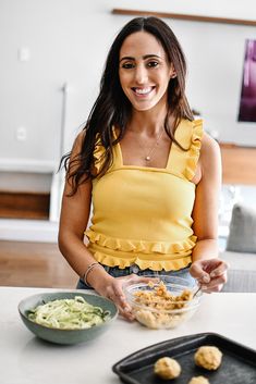 a woman is smiling while holding a bowl of food