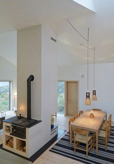 a dining room with a wood stove in the center and an area rug on the floor