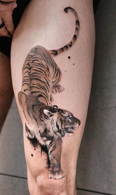 a tiger tattoo on the leg of a man