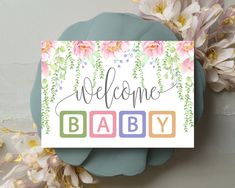 a welcome baby card sitting on top of flowers