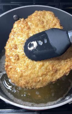 fried food being cooked in a frying pan with an electric spatula on top