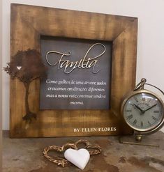 a wooden frame with a heart and a clock on the table in front of it