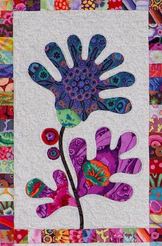 a patchwork quilt with an image of a purple flower on the front and bottom