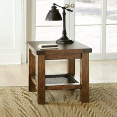 a small wooden table with a lamp on top