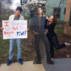 two men and a woman holding a sign that says i say yes to dear prom?