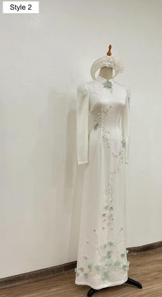 a white dress is on display in front of a wall