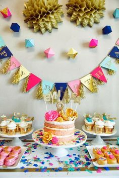 a table topped with lots of cakes and cupcakes