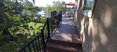 there is a deck with steps leading up to the water and trees in the background