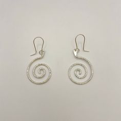 Sterling silver swirl dangle earrings with French hook wires, a unique and elegant design. Handmade by Zuni artist, Carlton Jamon. Measurements: 2" x 0.9" (including wire) Weight: 0.19oz (5.4g) Material: sterling silver (silver925) Elegant Hand Forged Swirl Earrings, Elegant Swirl Shaped Hand Forged Earrings, Elegant Swirl Wire Wrapped Earrings, Modern Twist Swirl Earrings For Gifts, Elegant Spiral Sterling Silver Wrap Earrings, Modern Twist Silver Jewelry With Ear Wire, Sterling Silver Drop Earrings With A Modern Twist, Modern Twist Silver Spiral Earrings, Modern Twist Sterling Silver Drop Wrap Earrings