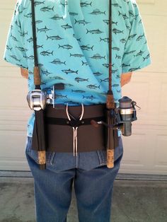 the back of a man with fishing rods attached to his waist and suspenders on