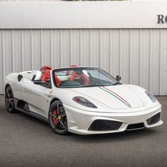 a white sports car parked in front of a building