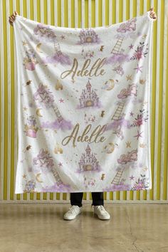 a woman holding up a white towel with princess castle on it and the words hello little