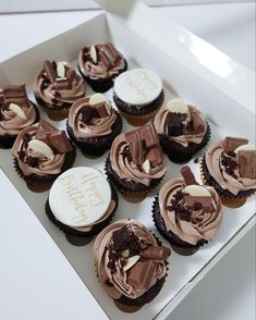 a box filled with chocolate cupcakes covered in frosting