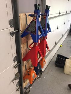 three blue and red cones are attached to a wall in a garage with other tools