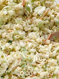 macaroni salad in a white bowl with a wooden spoon