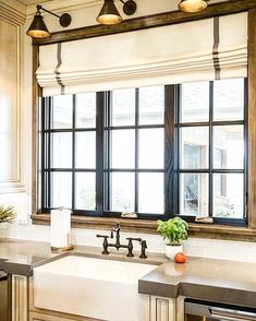 a kitchen sink under a window next to a dishwasher