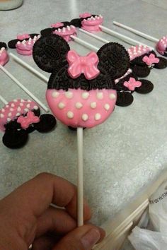 there is a cake that looks like minnie mouse on top of some lollipops