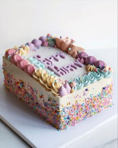 a birthday cake with sprinkles and frosting on it's side