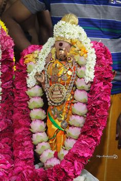 the idol is surrounded by flowers and garlands