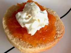 a piece of bread topped with whipped cream on top of an orange jelly dessert dish