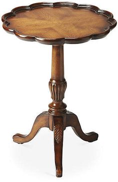 an old wooden table with a small round top on it's legs and feet