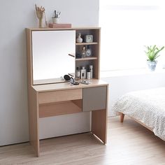 a bedroom with a bed, desk and mirror