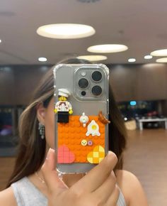 a woman taking a selfie with her phone case made to look like legos