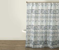 a blue and white shower curtain hanging on a wall next to a bathtub in a bathroom