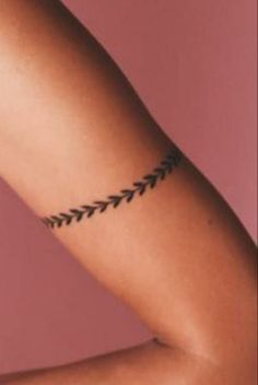 a woman's arm with an arrow tattoo on the left side of her arm