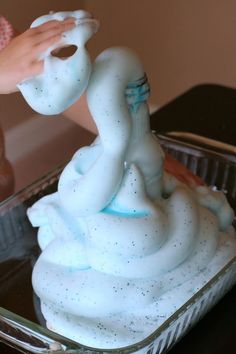 a person is decorating a cake with white frosting