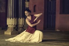 a woman sitting on the ground in a dress