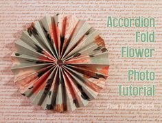 an accordion fold flower on top of a piece of paper with words written below it