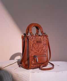 Made of synthetic leather Floral tooled with hand coloring A zippered pocket on the front of the small crossbody bag Top button closure An open pocket on the back Adjustable and detachable shoulder strap(Drop: 25.5"-29") 5.3"(L) x 3"(W) x 7.5"(H) Interior Capacity: Extra Small Brown Embossed Crossbody Shoulder Bag, Montana West Purse, Western Designs, Western Shoes, Western Purses, Leather Floral, Western Design, Travel Duffle, Duffle Bag Travel