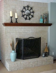 a living room with a fire place and candles on top of the fireplace mantel