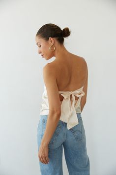 Channel your inner it-girl in the Hallie Strapless Open Back Satin Top! This crop top features a tie back closure, cowl open back, and strapless satin fit! Available in Rose Gold and Champagne; Pair this shimmery top with some jeans to polish off the perfect going out outfit!Details: Self: 97% Polyester, 3% Spandex Lining: 100% Polyester Some Stretch Tie Back Closure Partially Lined Hand Wash Cold/ Line Dry Silk Going Out Tops, Backless Tube Top For Night Out In Spring, Spring Backless Tube Top For Night Out, Glamorous Backless Halter Top For Spring, Chic Halter Neck Tube Top With Built-in Bra, Backless Tube Top For Date Night, Night Out Halter Top With Tie Back, Chic Tie Back Crop Top For Date Night, Sleeveless Party Top With Bow Tie Back