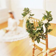 two wooden chairs decorated with flowers and greenery