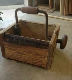 an old wooden box with a handle on the floor