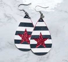 pair of earrings with red stars on black and white stripes