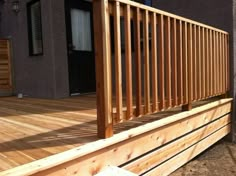 a wooden deck with railing and steps leading to a house