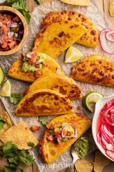 mexican food with tortillas, salsa and guacamole on the side