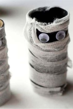 two rolls of toilet paper with googly eyes on them are sitting next to each other